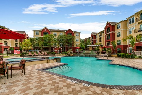 a swimming pool with an apartment building in the background