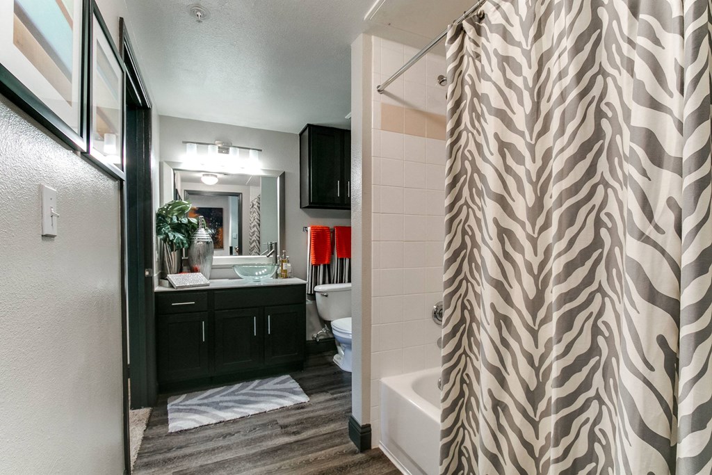 a bathroom with a shower curtain and a toilet and sink