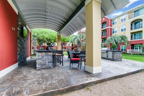 a covered patio with tables and chairs at an apartment building