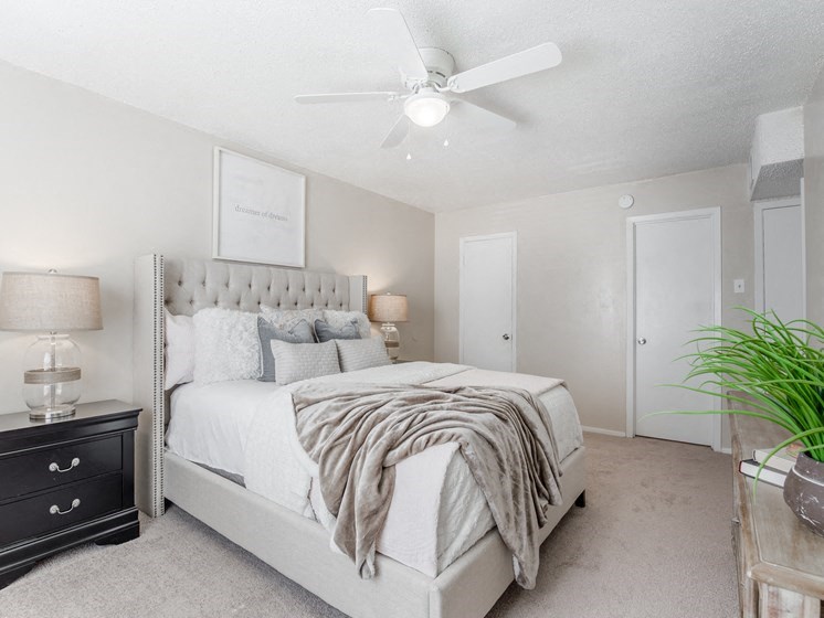 a bedroom with a large bed and a ceiling fan