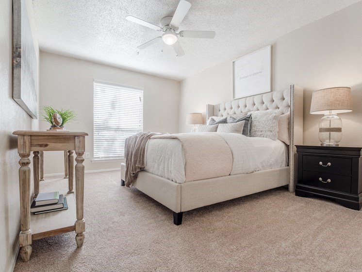 a bedroom with a bed and a ceiling fan
