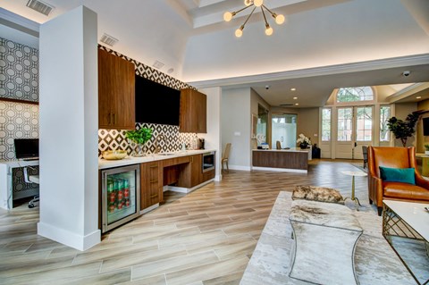 a large living room with a kitchen and a rug
