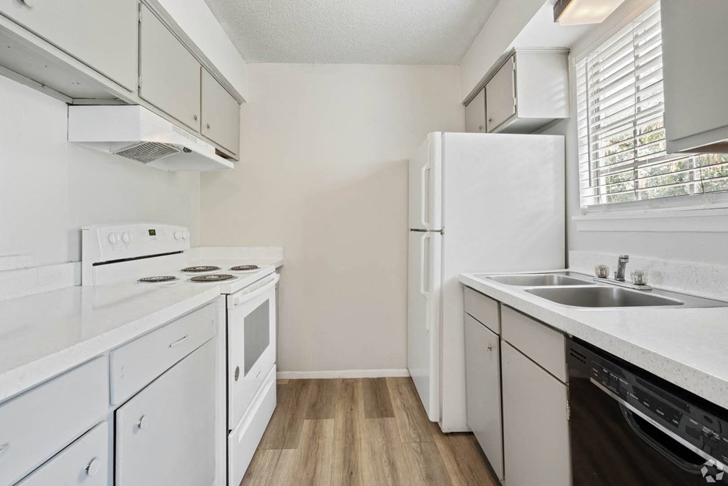 a kitchen with white appliances and white cabinets