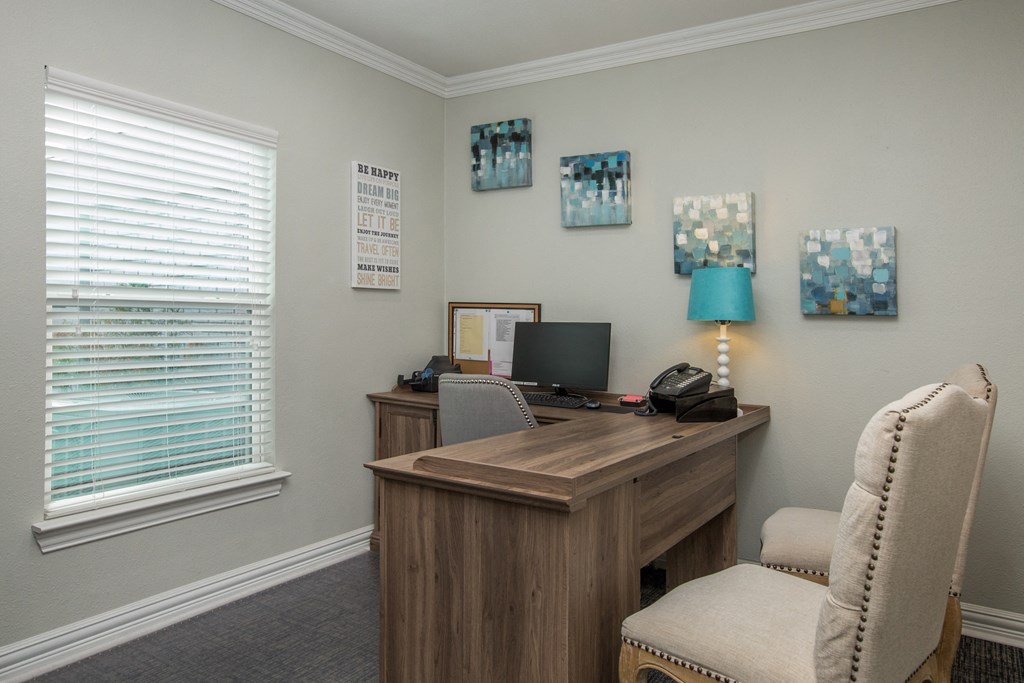 a office with a desk and a chair and a window