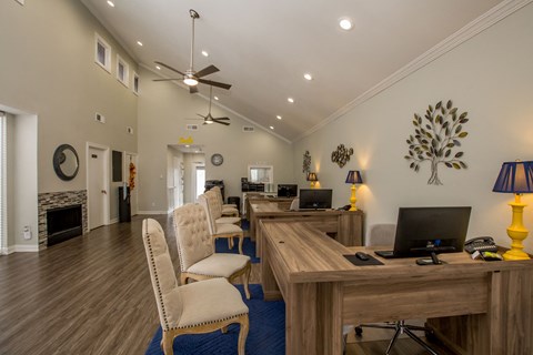 a living room with a desk and chairs and a fireplace