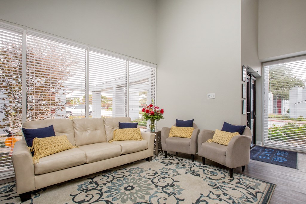 a living room with a couch and two chairs and a rug