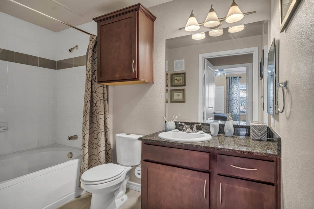 A bathroom with a white toilet and a white bathtub.