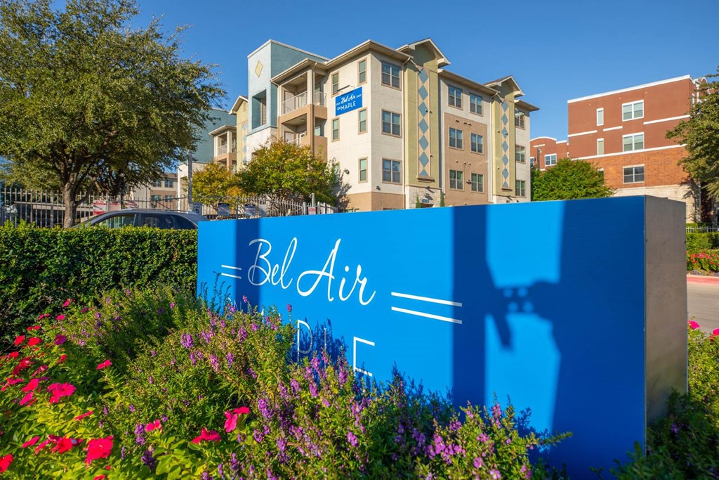 A blue sign with the words "Bell Air" on it in front of a building.