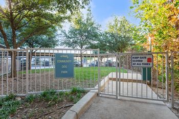 A sign at a gate reads "Community Dog Park" and "Keep Gate Closed at All Times.".