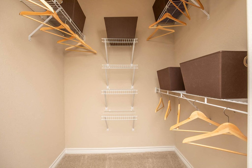 A walk-in closet with shelves and hangers.