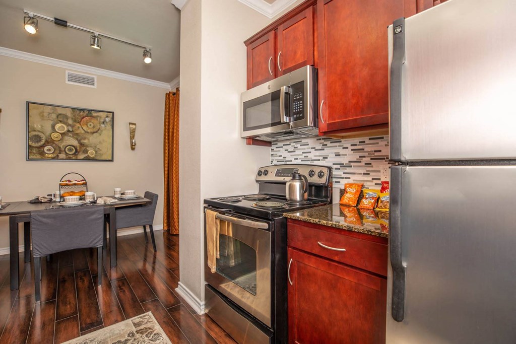 A kitchen with a stove top oven and a refrigerator.