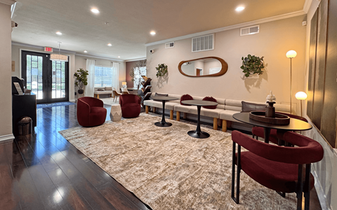 A room with a rug and chairs.