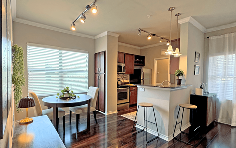 A kitchen with a table and chairs in front of a window.