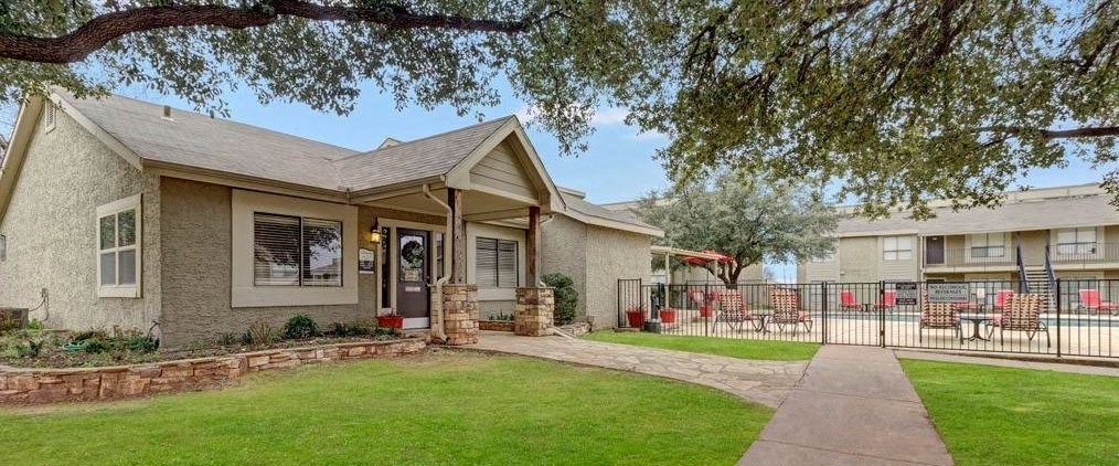 a house with a yard and a wrought iron fence