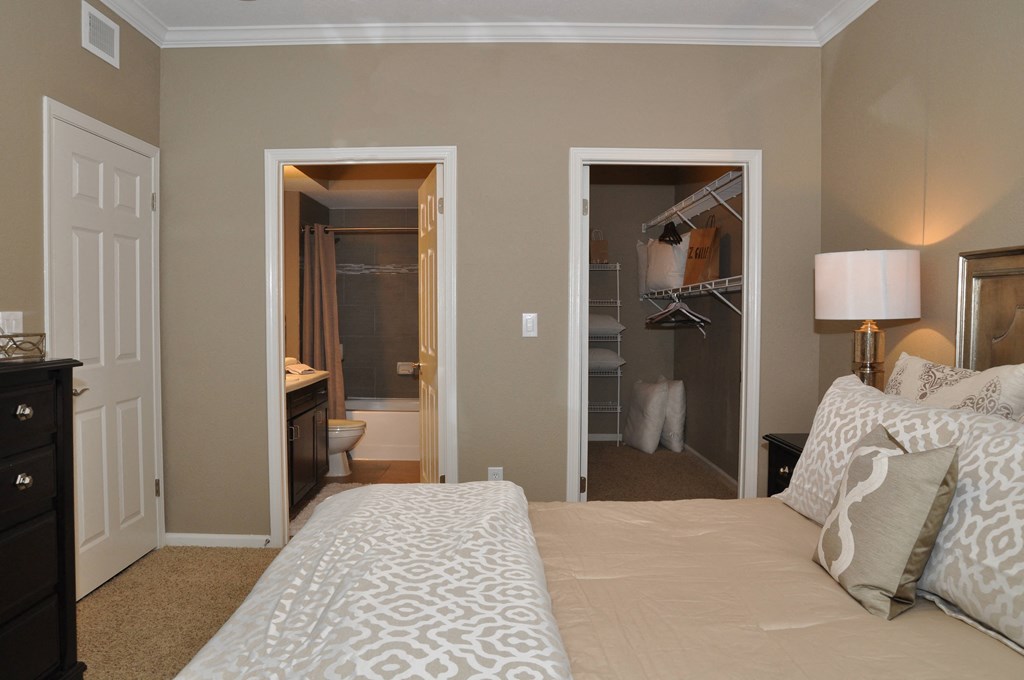 a bedroom with a bed and a closet and a bathroom
