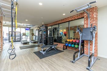 A gym with a variety of equipment including a squat rack, bench, and weights.