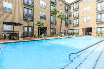 A large swimming pool in front of apartment buildings.