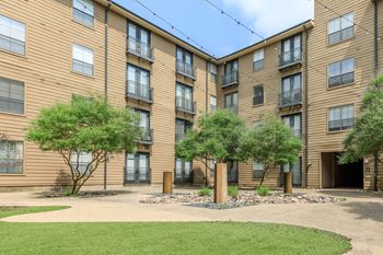 A brown building with a green lawn in front.