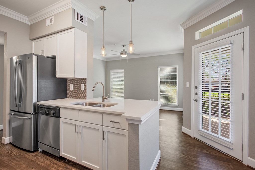 a kitchen with white cabinets and a stainless steel refrigerator