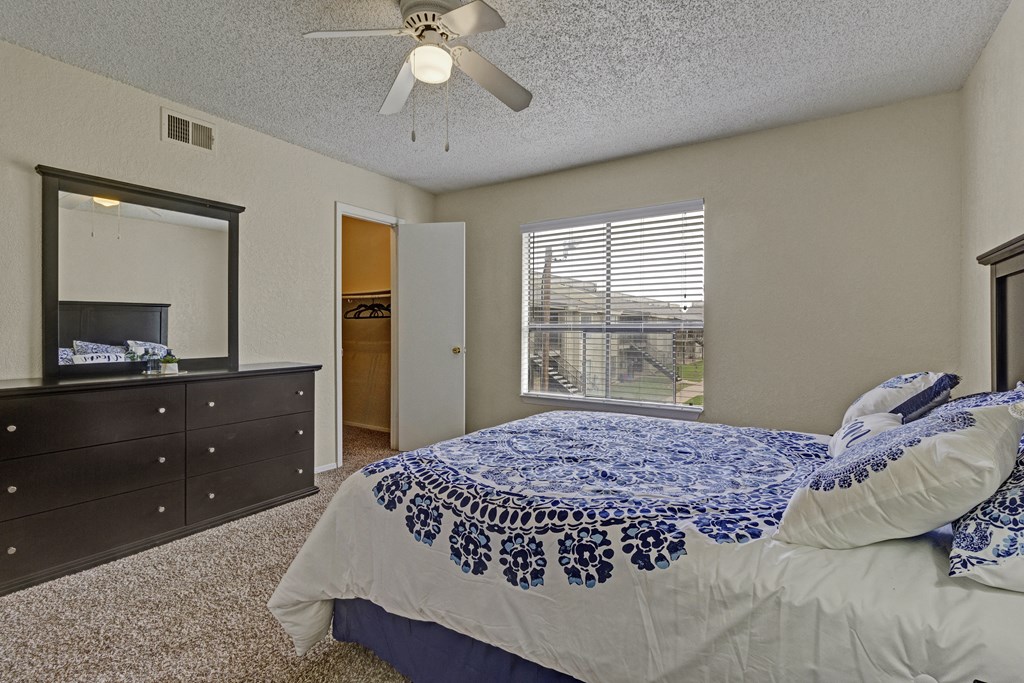 a bedroom with a large bed and a ceiling fan