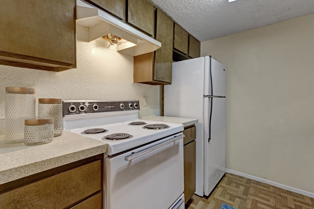 a kitchen with white appliances and a refrigerator