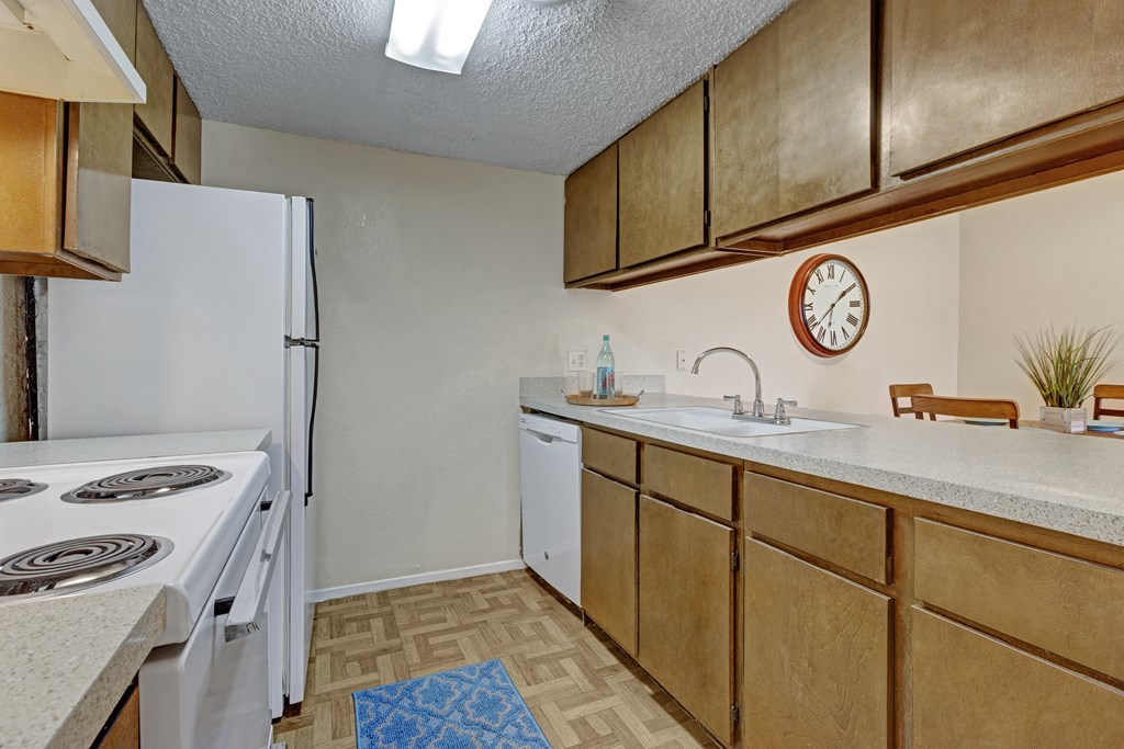 our redesigned kitchen with white appliances and wood cabinets   the kitchen is equipped with