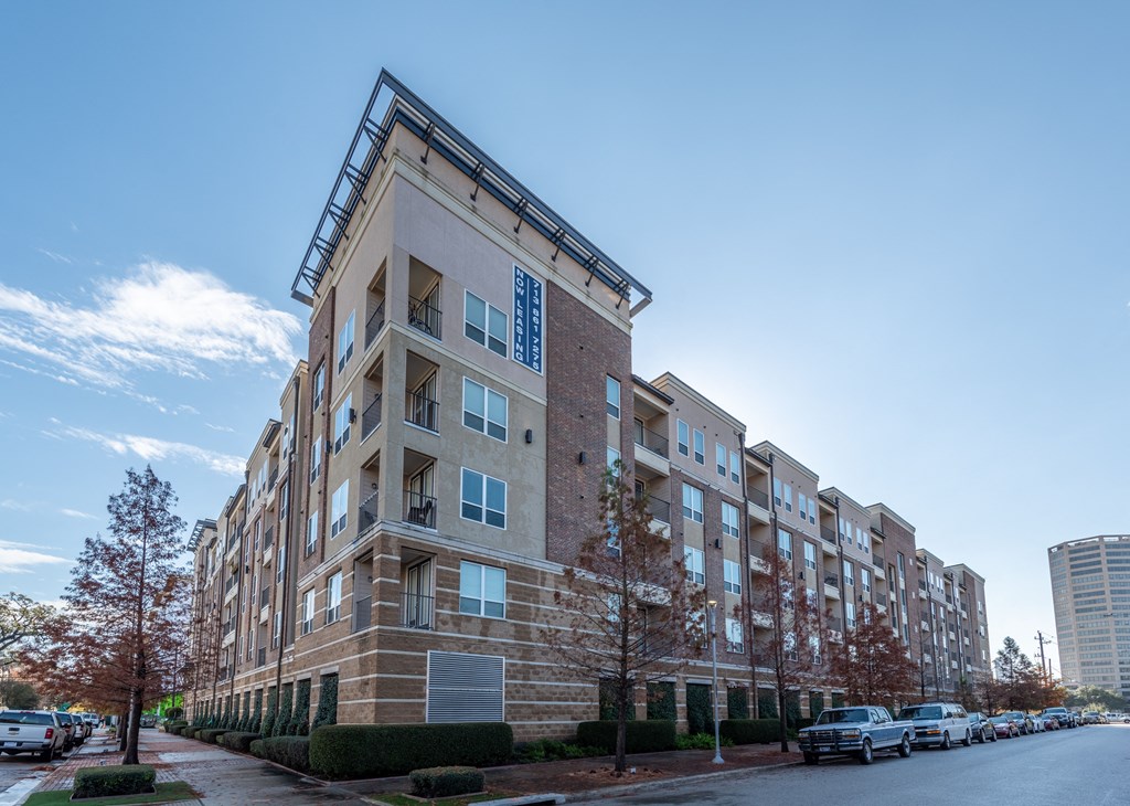 an apartment building on a street with cars parked in front of it
