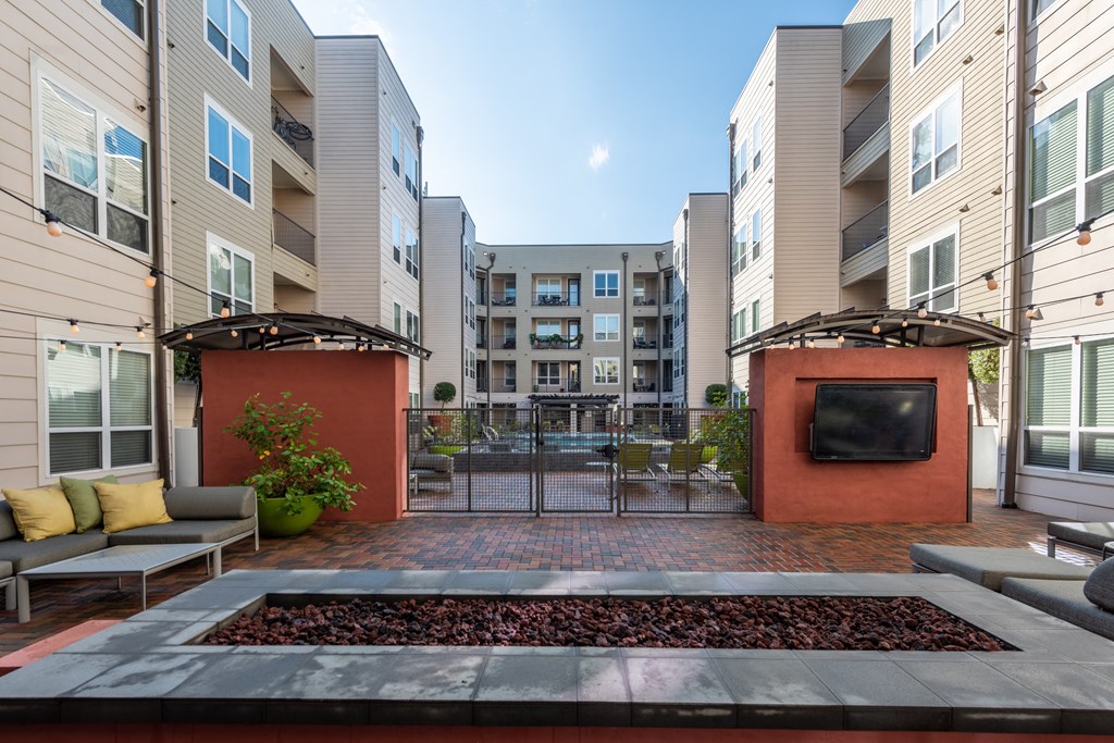 an apartment courtyard with a fire pit and a tv