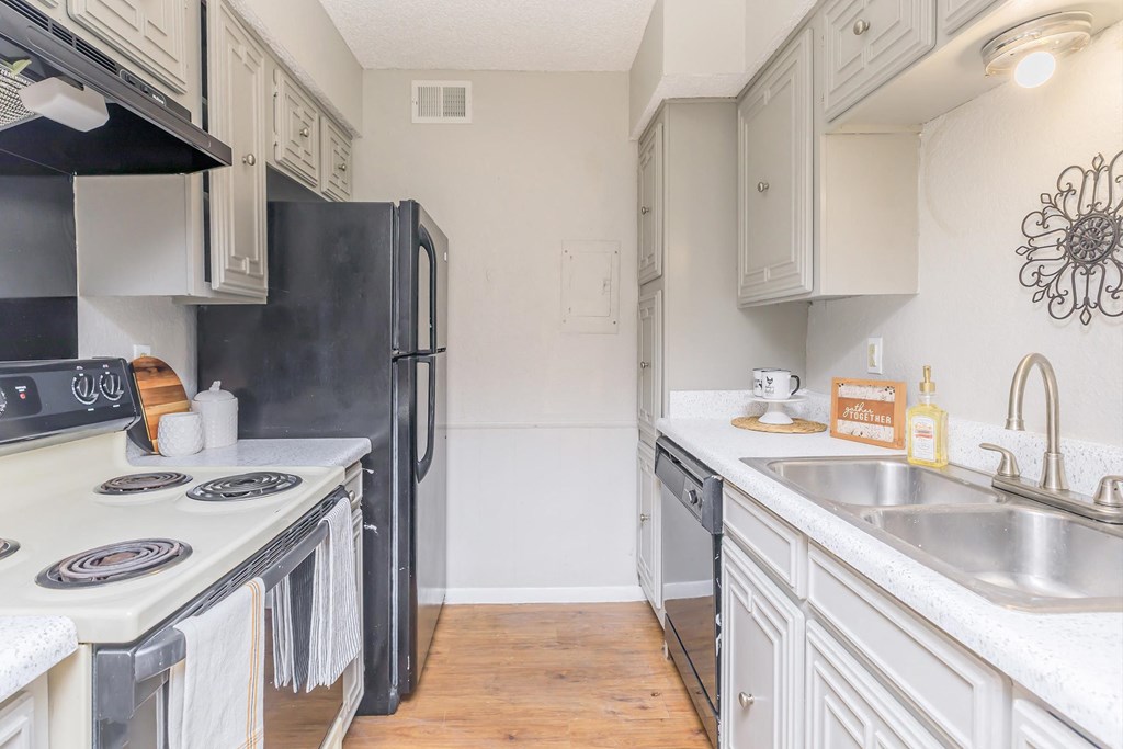 a kitchen with white cabinets and a sink and a refrigerator