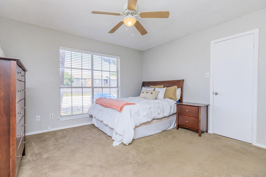 a bedroom with a bed and a ceiling fan