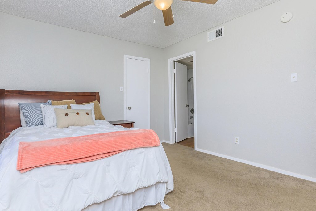 a bedroom with a bed and a ceiling fan