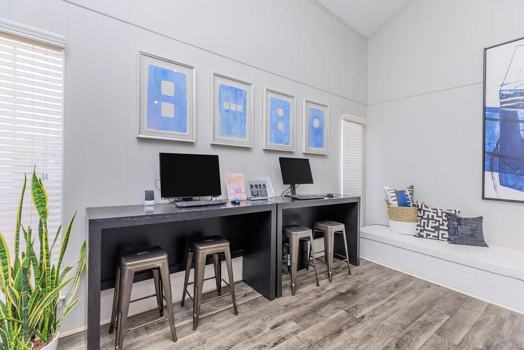 a office with a desk and three stools