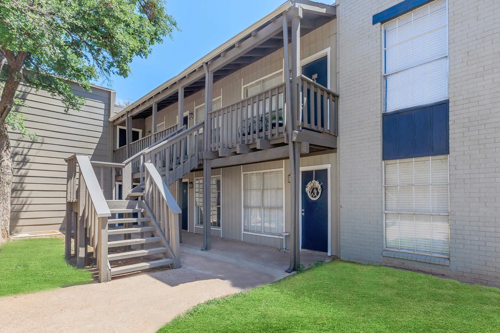 an apartment building with stairs and a balcony on the side of it