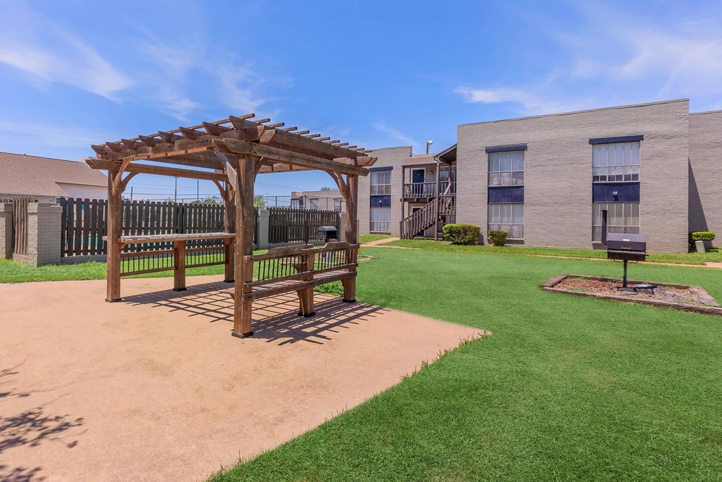 a gazebo with a bench in front of a building