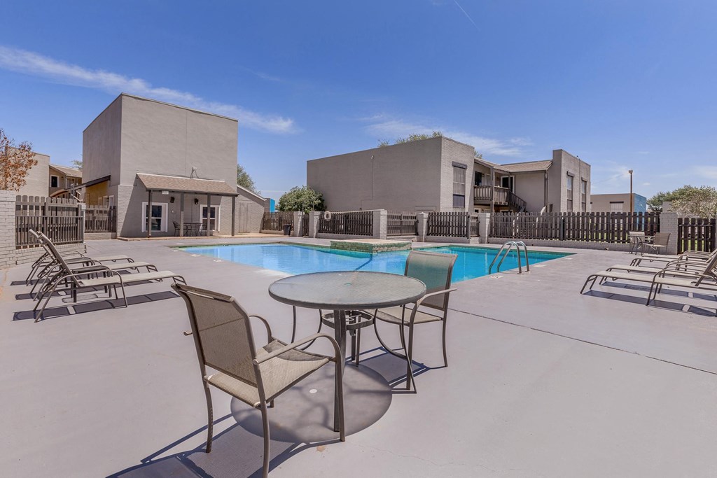 our apartments have a pool and patio with chairs and tables