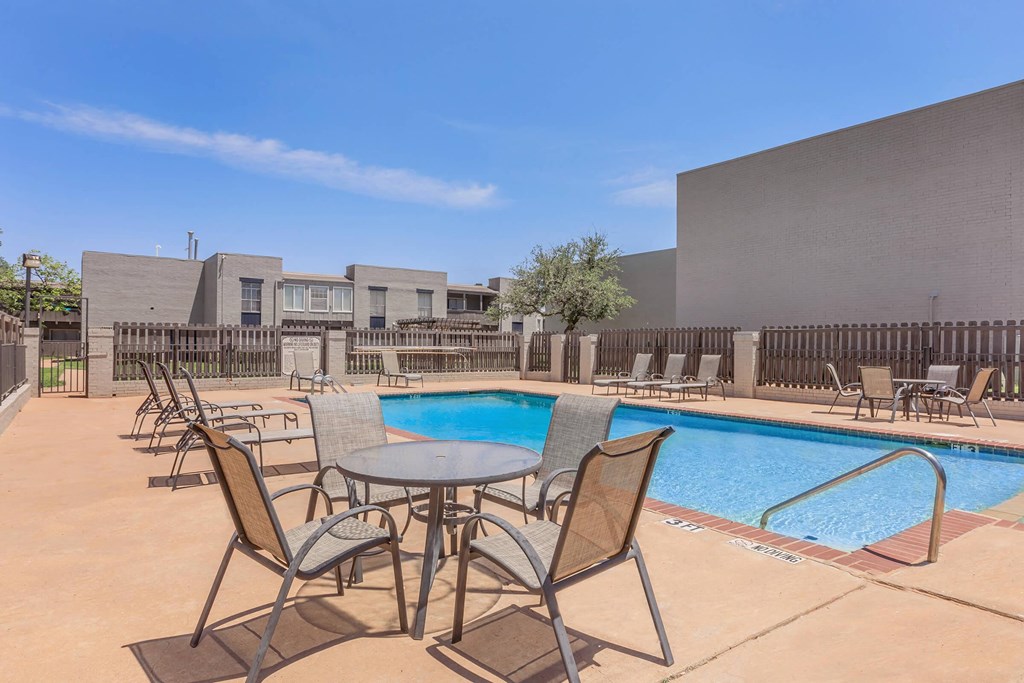 our apartments have a pool and patio with chairs and tables