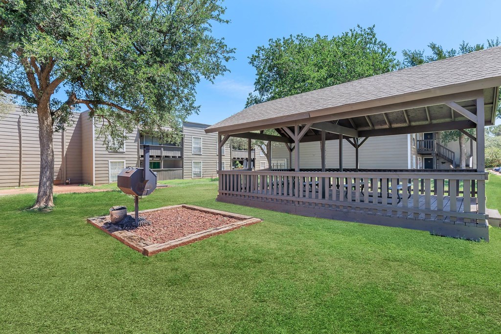 a covered porch with a stop sign in the grass