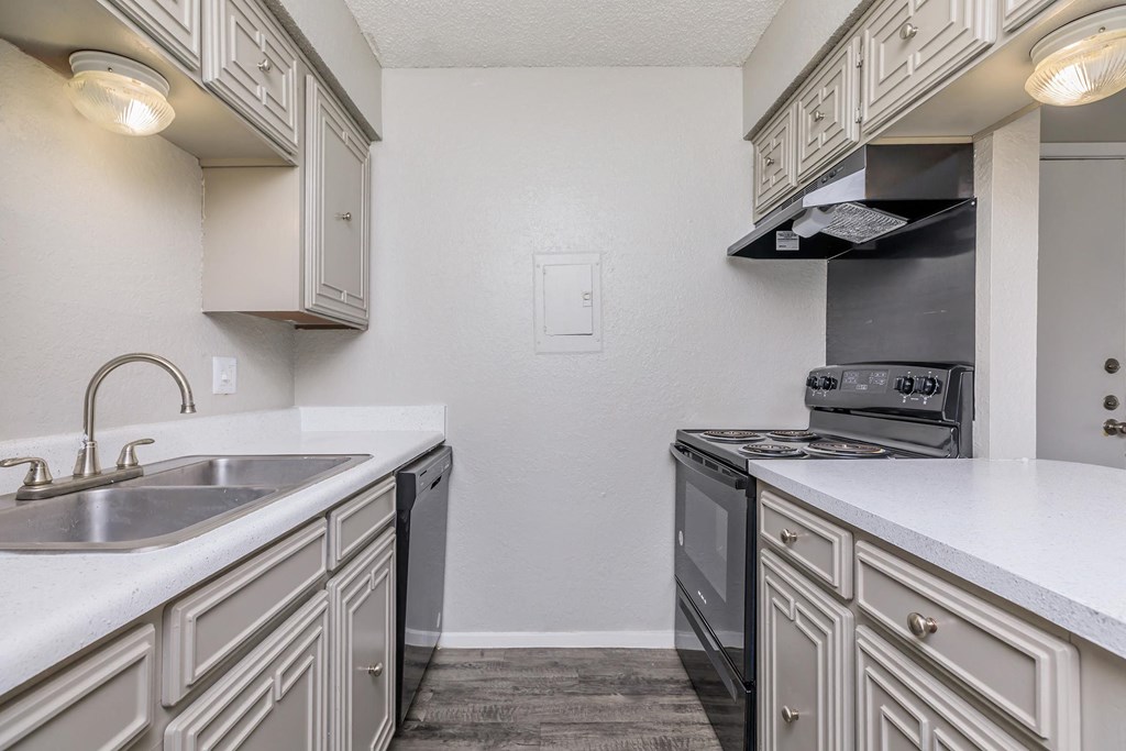 a kitchen with white cabinets and a sink and a stove