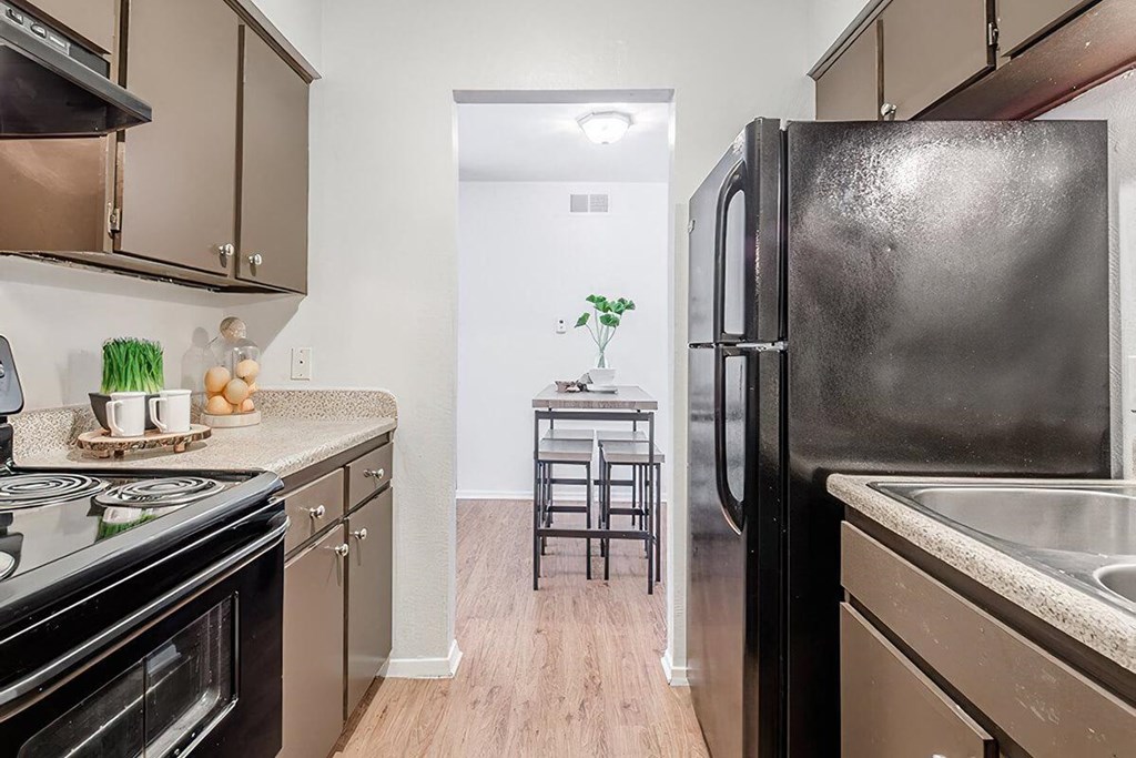 a kitchen with stainless steel appliances and a black refrigerator