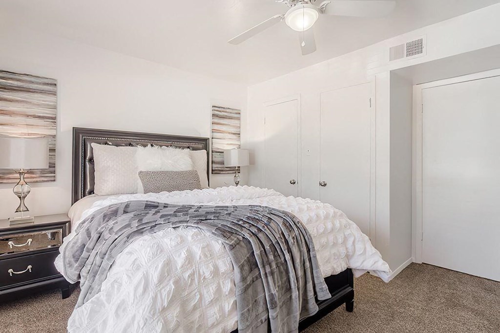 a bedroom with a bed and a ceiling fan