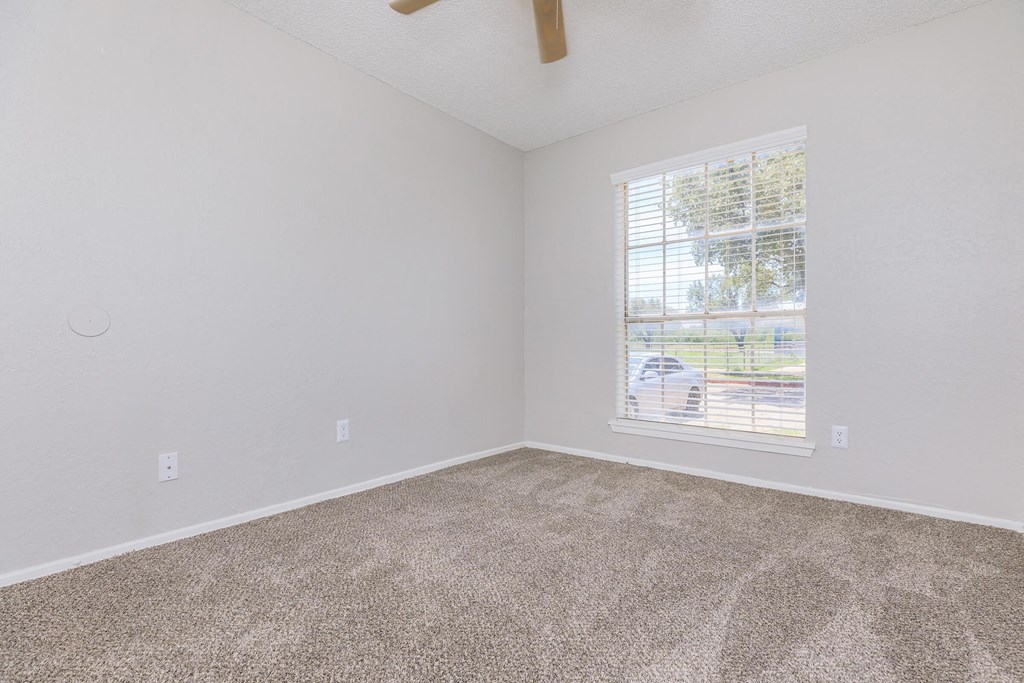 an empty room with carpet and a window