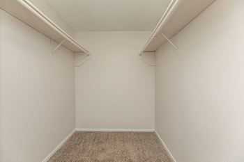 an empty room with white walls and two shelves on the wall