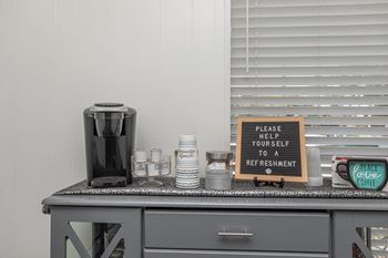 a kitchen counter with a coffee maker and a sign that says praise your self to