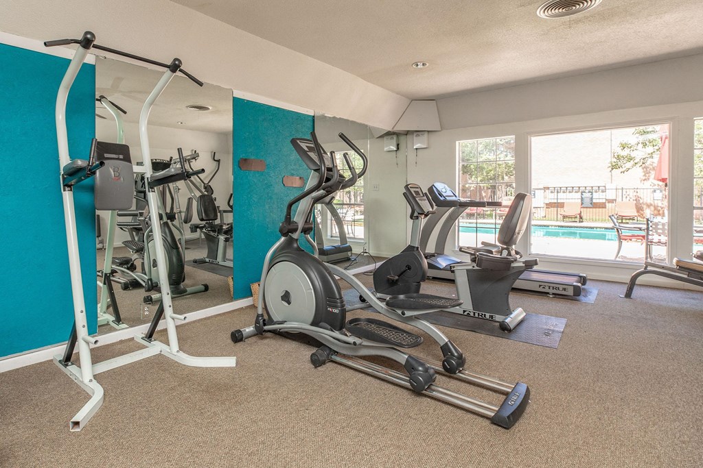 a gym with exercise equipment and a pool