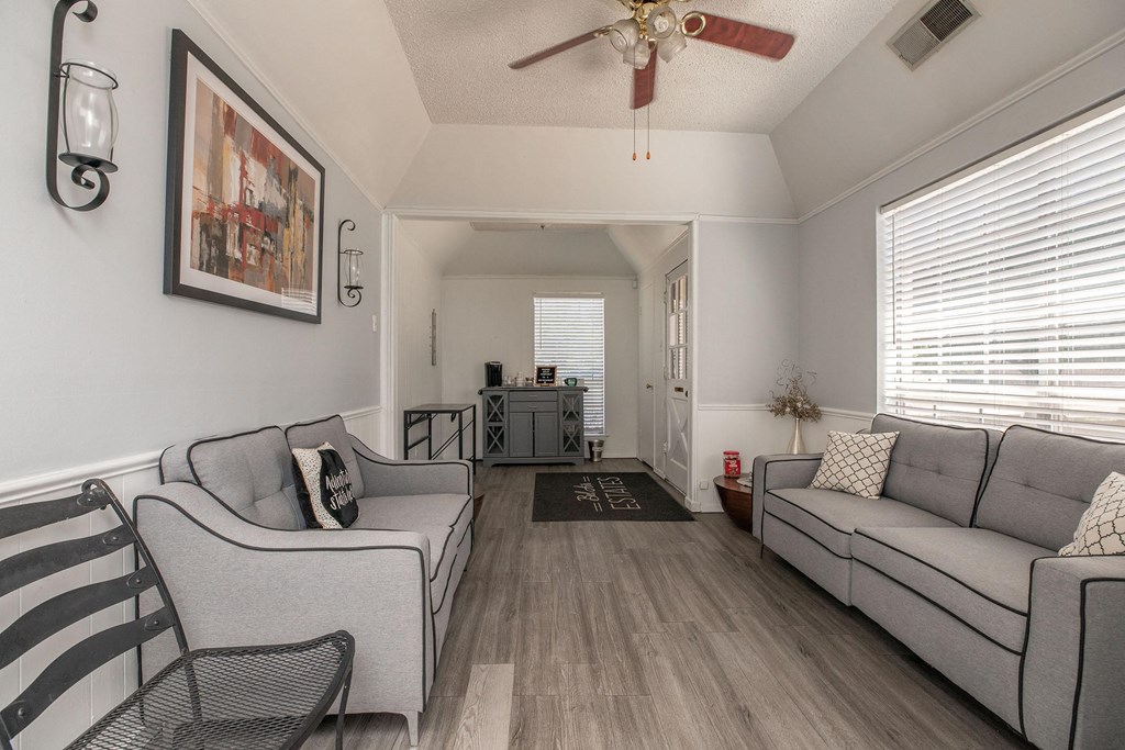 a living room with two couches and a ceiling fan