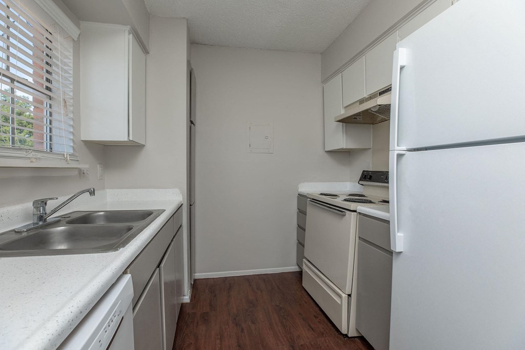 an empty kitchen with white appliances and white cabinets