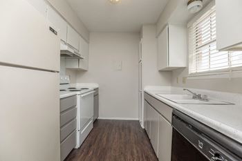 a kitchen with white cabinets and white appliances and a wood floor