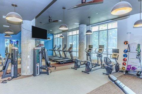 a gym with treadmills and other exercise equipment and windows