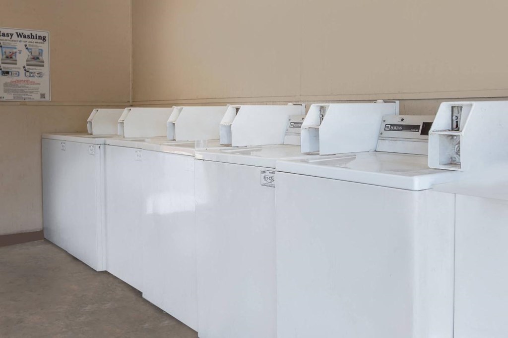 a row of white washing machines in a room