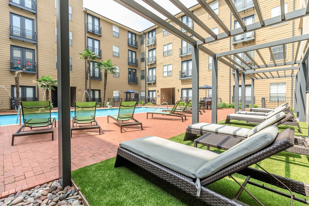 A patio area with sun loungers and a pool.